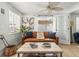Charming living room with a cozy leather sofa, neutral walls, and a ceiling fan at 501 Janice Pl, Indian Rocks Beach, FL 33785