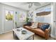 Comfortable living room with a leather sofa, plenty of natural light, and a decorative ceiling fan at 501 Janice Pl, Indian Rocks Beach, FL 33785