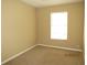 This cozy bedroom features neutral carpeting, beige walls, and a bright window at 5110 Sunridge Palms Dr, Tampa, FL 33617