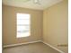 This cozy bedroom features neutral carpeting, beige walls, and a bright window at 5110 Sunridge Palms Dr, Tampa, FL 33617