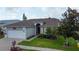 Well-manicured front yard, two-car garage, and beautiful flowering tree at 550 Salmon Ct, Oldsmar, FL 34677