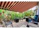 Back patio with brick pavers, red and white awning, and lush tropical landscaping at 550 Salmon Ct, Oldsmar, FL 34677