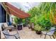 Charming brick patio with retractable awning, fire pit, and beautiful landscaping at 550 Salmon Ct, Oldsmar, FL 34677