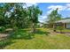 Lush backyard featuring mature trees and green grass, perfect for outdoor enjoyment and relaxation at 6104 Palm Ave, Gibsonton, FL 33534