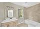 Bright bathroom features a large vanity, a bath tub, and neutral tile at 6104 Palm Ave, Gibsonton, FL 33534