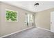 Neutral bedroom features plush carpeting and natural light from two windows at 6104 Palm Ave, Gibsonton, FL 33534