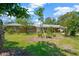 Well-maintained front lawn showcasing a single-story brick home with manicured landscaping and mature trees at 6104 Palm Ave, Gibsonton, FL 33534