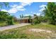 Single story home with a long driveway and mature, shady trees at 6104 Palm Ave, Gibsonton, FL 33534