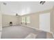Bright living room features neutral paint, carpeted floors, large windows and ceiling fan at 6104 Palm Ave, Gibsonton, FL 33534