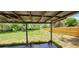 An open backyard features a covered patio, lush grass, and a fire pit at 6825 Hammock Rd, Port Richey, FL 34668