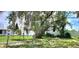 The large backyard is fenced with a gate and features mature trees at 6825 Hammock Rd, Port Richey, FL 34668