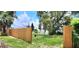The home boasts a backyard with a wood fence, grassy area, and mature landscaping at 6825 Hammock Rd, Port Richey, FL 34668