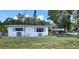 Inviting single-story home featuring a well-maintained lawn, fenced yard, and classic curb appeal at 6825 Hammock Rd, Port Richey, FL 34668