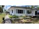 Cozy single-story home with a landscaped front yard, a side door and a sidewalk at 6825 Hammock Rd, Port Richey, FL 34668