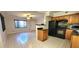 Kitchen featuring black appliances, wood cabinets, granite countertops, and tile flooring at 6825 Hammock Rd, Port Richey, FL 34668