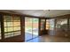 Bright sun room with multiple windows and a sliding glass door at 6825 Hammock Rd, Port Richey, FL 34668