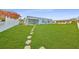 Large backyard with a stepping stone path leading to the covered patio at 710 116Th Ave, Treasure Island, FL 33706