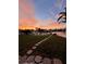 Backyard with a path leading to the water and vibrant sunset views at 710 116Th Ave, Treasure Island, FL 33706