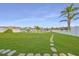Lush backyard featuring a stone path leading to a fenced waterfront at 710 116Th Ave, Treasure Island, FL 33706