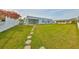 Spacious backyard with a well-maintained lawn and stepping stones leading to the house at 710 116Th Ave, Treasure Island, FL 33706