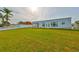 Spacious backyard featuring lush green grass, fenced-in yard, and patio area at 710 116Th Ave, Treasure Island, FL 33706