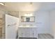 Bathroom featuring a double vanity, large mirror, and a separate shower with marble-like tile at 710 116Th Ave, Treasure Island, FL 33706