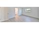 Bedroom with light-colored, wide plank flooring, an open door to the bathroom, and a window at 710 116Th Ave, Treasure Island, FL 33706