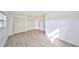 A bright bedroom featuring wood-look floors, bright white walls, and a closet at 710 116Th Ave, Treasure Island, FL 33706