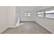 A sunny bedroom featuring wood-look floors, bright white walls, and two windows at 710 116Th Ave, Treasure Island, FL 33706