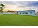 Exterior view of the home with a large backyard and covered patio at 710 116Th Ave, Treasure Island, FL 33706