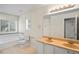 Bathroom featuring a double sink vanity, soaking tub with tile accent, and a window at 7249 Bridgeview Dr, Wesley Chapel, FL 33545