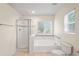 Bright bathroom featuring a shower, bathtub, and window at 7249 Bridgeview Dr, Wesley Chapel, FL 33545