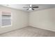 Cozy bedroom with neutral walls and carpet featuring a ceiling fan and a window at 7249 Bridgeview Dr, Wesley Chapel, FL 33545