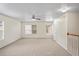 Bright bonus room with neutral walls and carpet features a ceiling fan and two windows at 7249 Bridgeview Dr, Wesley Chapel, FL 33545