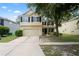 Charming two-story home with attached two-car garage, manicured lawn, and mature trees at 7249 Bridgeview Dr, Wesley Chapel, FL 33545