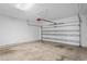 A view of the garage, with door and concrete floors, ready for parking and storage at 7249 Bridgeview Dr, Wesley Chapel, FL 33545