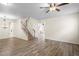 Bright living room featuring hardwood floors, ceiling fan, and staircase at 7249 Bridgeview Dr, Wesley Chapel, FL 33545