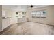 Spacious living room with hardwood floors, plenty of natural light and view into the kitchen at 7249 Bridgeview Dr, Wesley Chapel, FL 33545