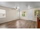Sunlit living room showcases hardwood floors, ceiling fan, and a welcoming front entrance at 7249 Bridgeview Dr, Wesley Chapel, FL 33545