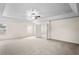Spacious main bedroom with a tray ceiling and carpeted floors featuring a ceiling fan and two windows at 7249 Bridgeview Dr, Wesley Chapel, FL 33545
