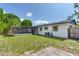 An exterior shot of the backyard with a screened-in patio and a grassy area perfect for outdoor activities at 7500 16Th N St, St Petersburg, FL 33702