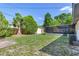Expansive backyard featuring green grass, lush trees, screened patio, and storage shed at 7500 16Th N St, St Petersburg, FL 33702