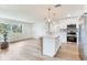 Open kitchen and living space features white cabinets, stainless steel appliances, and a central island at 7500 16Th N St, St Petersburg, FL 33702
