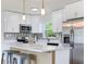 Bright kitchen with white cabinets, quartz countertops, stainless steel appliances, and center island with seating at 7500 16Th N St, St Petersburg, FL 33702