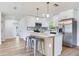 Open concept kitchen with island, white cabinets, modern lighting, stainless steel appliances, and stylish backsplash at 7500 16Th N St, St Petersburg, FL 33702