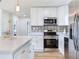 Charming kitchen with white cabinets, stainless steel appliances, quartz countertops, and an island with seating at 7500 16Th N St, St Petersburg, FL 33702