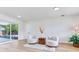 Bright living room with neutral decor, two armchairs, and sliding glass doors to the outdoor area at 7500 16Th N St, St Petersburg, FL 33702