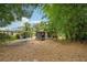 Backyard view with a carport and a small patio, surrounded by trees and some bamboo at 7511 N Ola Ave, Tampa, FL 33604