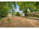 Leafy backyard featuring a storage shed and a carport visible through lush greenery at 7511 N Ola Ave, Tampa, FL 33604