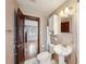 Bathroom with tile floor, pedestal sink, and a view of a bedroom through an open door at 7511 N Ola Ave, Tampa, FL 33604